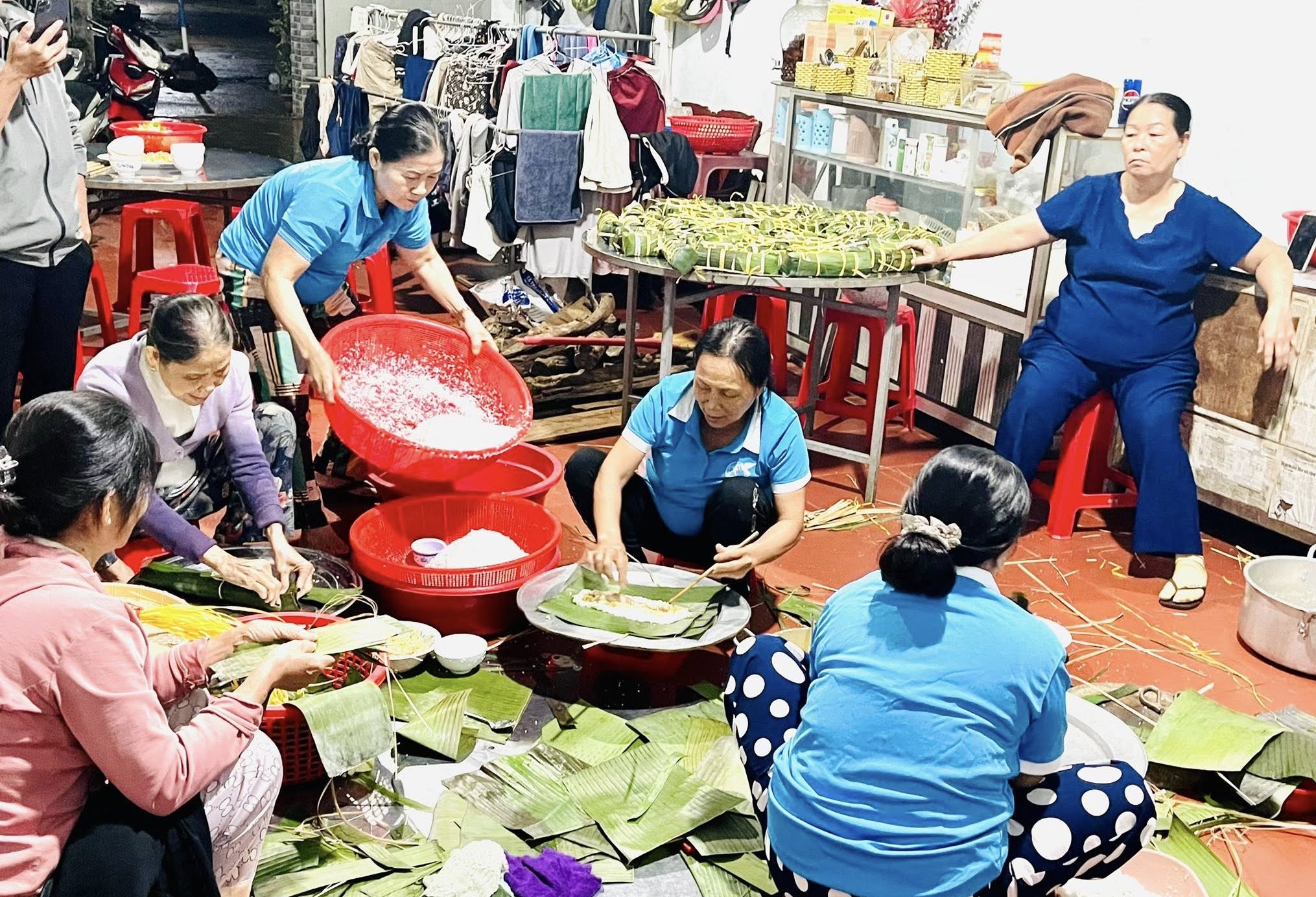 Hội viên phụ nữ thôn Phú Hòa gói bánh tét để gửi tặng người dân vùng bị ngập lụt tại các xã phía Đông tỉnh Đắk Lắk